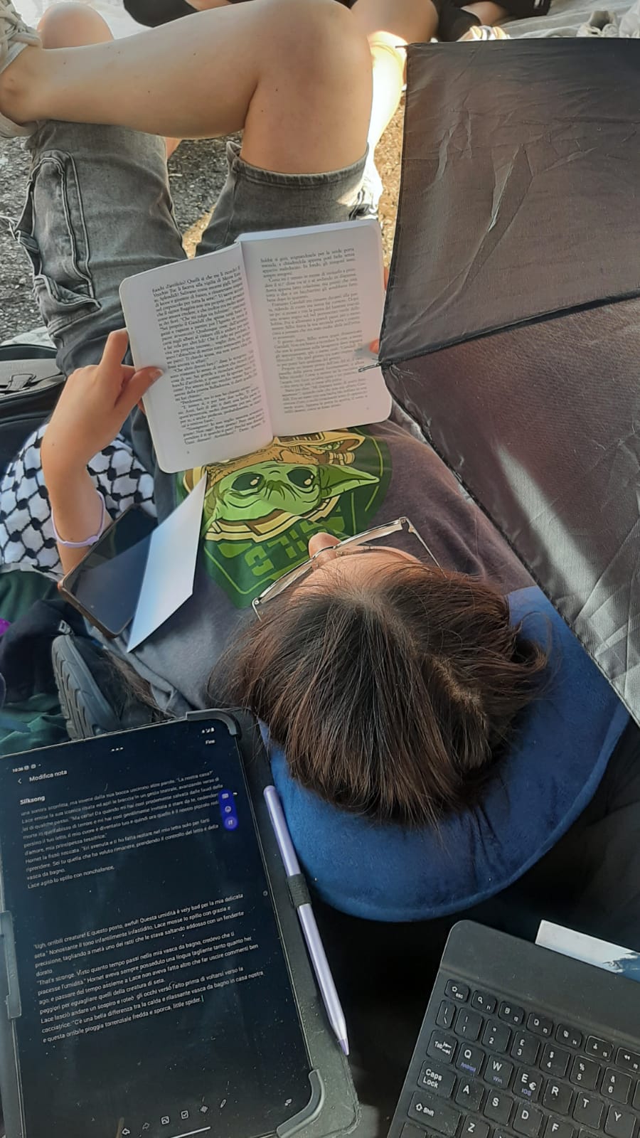 Lettura di un libro con tablet e tastiera accanto